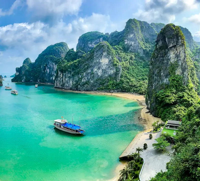 Boats on turquoise water among limestone karsts in Ha Long Bay